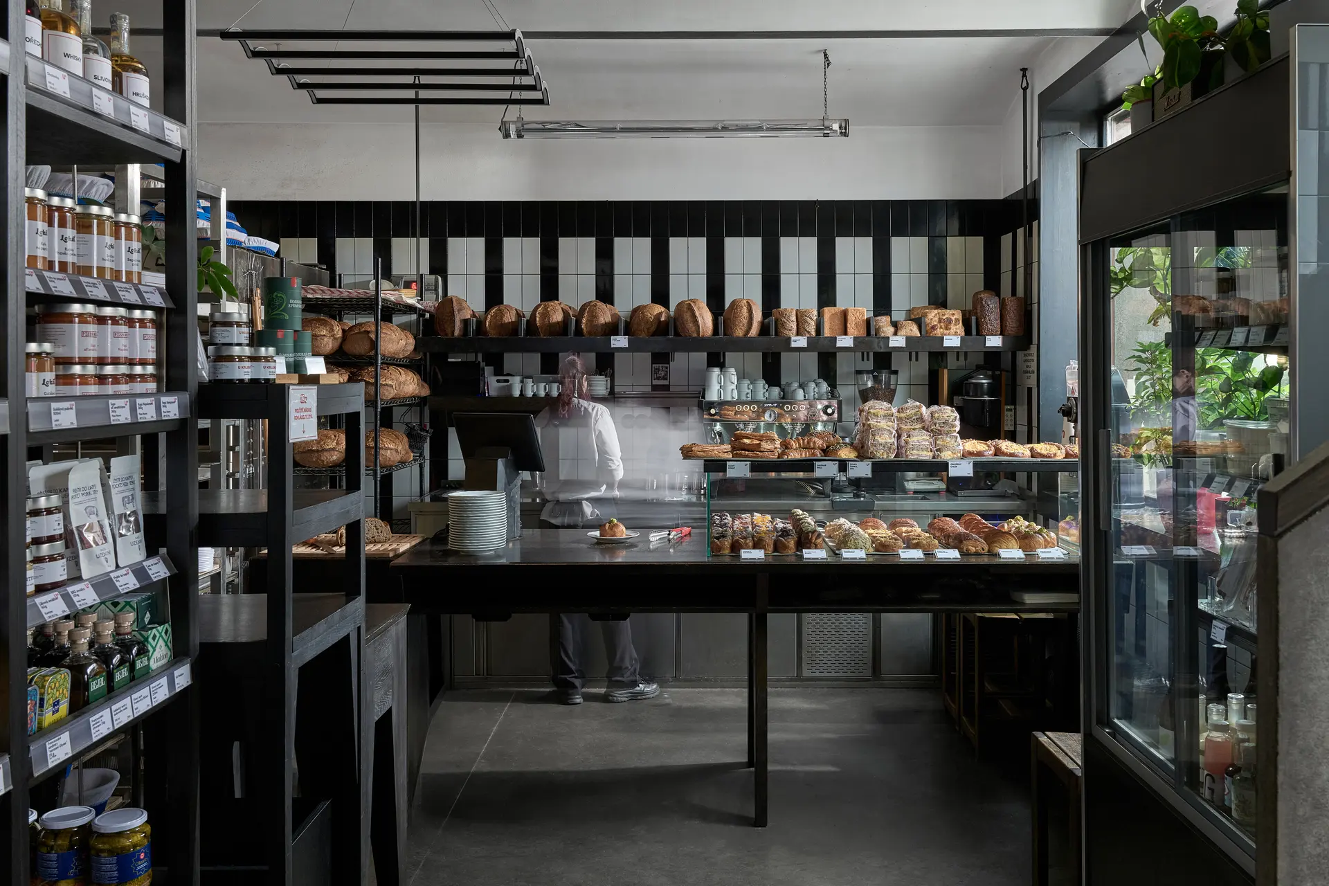 Bakery interior with pastry display and bread shelves.